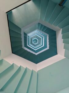 Vertical view of a geometric stairwell with a blue pattern in Puducherry, India.