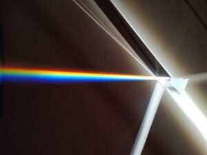 A colorful spectrum of light refracted through a glass prism creating a rainbow effect.